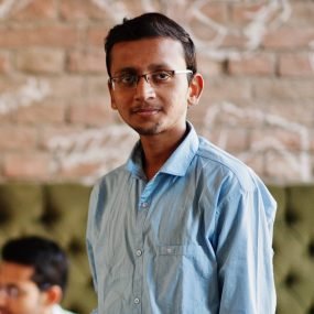 Group of four south asian men's posed at business meeting in cafe. Indians work together, having conversation. Indian man with cup of coffee.